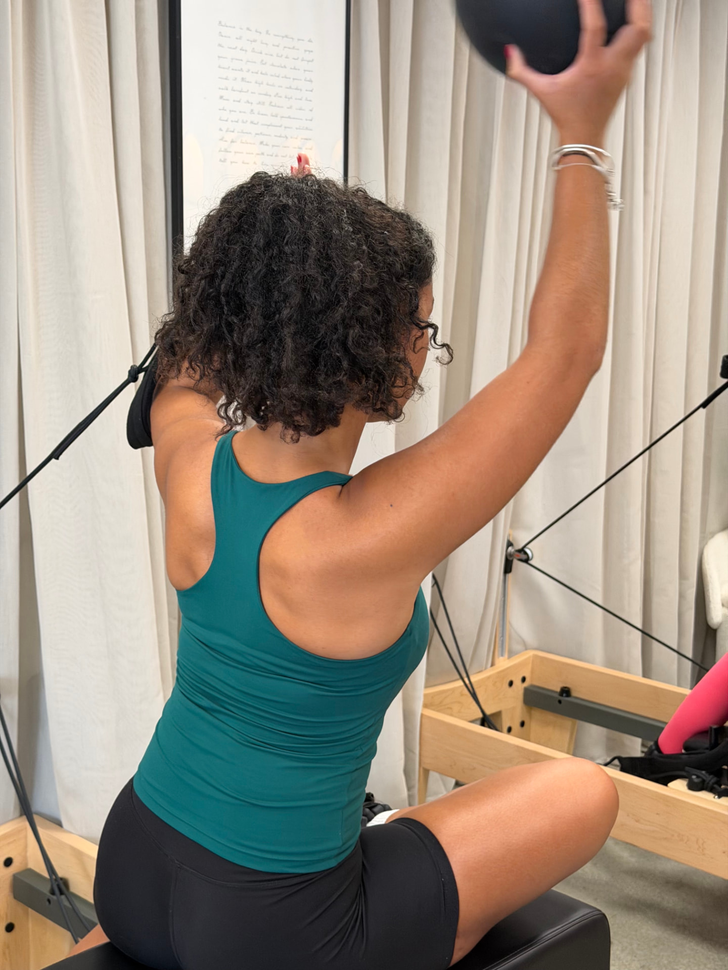 An attendee working with the Pilates ball on the Reformer at BED Debden